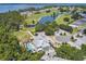 An aerial view overlooking the Deer Island Golf Clubhouse, swimming pool, and surrounding golf course with water features at 30215 Island Club Dr, Deer Island, FL 32778