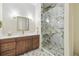 Modern bathroom with marble shower, bronze hardware, and hexagon tile floors at 30215 Island Club Dr, Deer Island, FL 32778