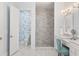 Bathroom featuring marble floors, glass enclosed shower, floral wall paper, and vanity with makeup table at 30215 Island Club Dr, Deer Island, FL 32778