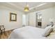 Bright bedroom featuring a tray ceiling, wood floors, and an ensuite bathroom at 30215 Island Club Dr, Deer Island, FL 32778