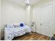 Cozy bedroom with floral bedding, wood floors, and a small bedside table at 30215 Island Club Dr, Deer Island, FL 32778