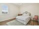 Light-filled bedroom with wood floors, floral bedding, and a large window at 30215 Island Club Dr, Deer Island, FL 32778