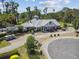 Beautiful view of the Deer Island Golf Clubhouse, manicured landscaping, and golf carts parked outside at 30215 Island Club Dr, Deer Island, FL 32778