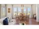 Dining area with large picture windows overlooking the water, adjacent to the living room at 30215 Island Club Dr, Deer Island, FL 32778