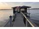 Boat dock with shelter displaying the American flag, providing a scenic view at 30215 Island Club Dr, Deer Island, FL 32778