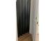 Black folding door hides an elevator entrance; access door is ajar, revealing wooden flooring at 30215 Island Club Dr, Deer Island, FL 32778
