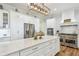 Modern kitchen features stainless steel appliances, an oversized island, and white cabinets at 30215 Island Club Dr, Deer Island, FL 32778