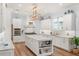 Gourmet kitchen features a professional range, custom cabinetry, marble countertops, island and gold hardware at 30215 Island Club Dr, Deer Island, FL 32778