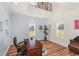 The home office features natural light, a blue accent wall, and a traditional wooden desk at 30215 Island Club Dr, Deer Island, FL 32778