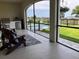 Screened patio with Adirondack chairs, outdoor kitchen, and a view of the pool at 30215 Island Club Dr, Deer Island, FL 32778