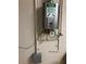 Modern Rinnai tankless water heater with an adjacent electric car charging station in a residential location at 30215 Island Club Dr, Deer Island, FL 32778