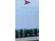 Exterior shot of the Mount Dora Yacht Club sign, with red and white sail logo and green shrubbery at 30215 Island Club Dr, Deer Island, FL 32778