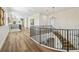 Spacious hallway featuring hardwood floors, decorative chandeliers and wrought iron banister at 30215 Island Club Dr, Deer Island, FL 32778