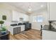 Well-lit laundry room with updated appliances, countertop, and a decorative chandelier at 30215 Island Club Dr, Deer Island, FL 32778