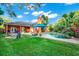 Backyard with a sparkling pool, lush landscaping, outdoor seating, and a unique outdoor fireplace at 3518 Edlingham Ct, Belle Isle, FL 32812