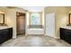 Luxurious bathroom with dual vanities, a soaking tub, and a glass-enclosed shower for a spa-like experience at 3518 Edlingham Ct, Belle Isle, FL 32812