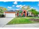 Charming single-story home with an attached garage, tropical landscaping, and a well-manicured lawn at 3518 Edlingham Ct, Belle Isle, FL 32812