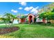 Single story home featuring a vibrant facade with lush tropical landscaping and a circular driveway at 3518 Edlingham Ct, Belle Isle, FL 32812