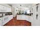 Well-lit kitchen featuring white cabinets, tile backsplash, and breakfast bar with view of fireplace at 3518 Edlingham Ct, Belle Isle, FL 32812