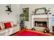 Comfortable living room featuring a stone fireplace, bright red rug, and stylish decor creating a welcoming atmosphere at 3518 Edlingham Ct, Belle Isle, FL 32812