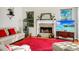 Bright living room with a stone fireplace, red rug, and comfortable white couches provides a cozy place for relaxation at 3518 Edlingham Ct, Belle Isle, FL 32812