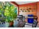 Covered outdoor dining area featuring grilling station, wood accents, and hanging plants at 3518 Edlingham Ct, Belle Isle, FL 32812
