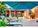 Relaxing covered patio featuring lounge seating, a grill, and views of the lush, tropical landscape at 3518 Edlingham Ct, Belle Isle, FL 32812