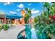 Inviting backyard oasis featuring a sparkling pool, lush tropical plants, a stylish patio, and outdoor seating at 3518 Edlingham Ct, Belle Isle, FL 32812