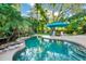 Backyard pool with a grotto-style feature surrounded by palm trees and ample patio space for lounging at 3518 Edlingham Ct, Belle Isle, FL 32812
