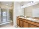 Bathroom showcasing double vanity sinks and a tiled walk-in shower at 3632 Solana Cir # B, Clermont, FL 34711