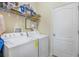 Functional laundry room equipped with washer, dryer, and storage shelving at 3632 Solana Cir # B, Clermont, FL 34711