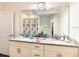 Spacious bathroom featuring a double vanity with granite countertops and a large mirror at 5352 Diplomat Ct # 107, Kissimmee, FL 34746