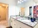 Well-lit bathroom boasts a double vanity with granite countertops and modern fixtures at 5352 Diplomat Ct # 107, Kissimmee, FL 34746