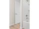 Bathroom with a bathtub, shower, white door, and wood-look floors at 580 Buchannan Dr, Davenport, FL 33837