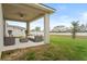 Covered outdoor patio has a ceiling fan, modern outdoor furniture, and a concrete fire pit at 580 Buchannan Dr, Davenport, FL 33837