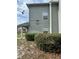 View of condo building 6100 with manicured bushes and neutral-colored siding at 6100 Westgate Dr # 203, Orlando, FL 32835
