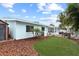 Exterior view of the home showcasing the well-maintained backyard with artificial turf, pergola, and charming details at 625 Worthington Dr, Winter Park, FL 32789