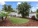 Green backyard featuring a pergola with hot tub, built-in bar, lush landscaping, and white privacy fence at 625 Worthington Dr, Winter Park, FL 32789