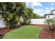 Lush backyard featuring artificial turf, mature palm trees, and white privacy fencing, creating a serene outdoor space at 625 Worthington Dr, Winter Park, FL 32789