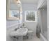 Bright bathroom featuring a pedestal sink, white wainscoting, and a window for natural light at 625 Worthington Dr, Winter Park, FL 32789