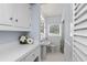 Small and bright bathroom with white fixtures, wainscoting and stylish decor at 625 Worthington Dr, Winter Park, FL 32789