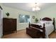 Bedroom with a wooden bed frame, chest, and a window offering natural light at 625 Worthington Dr, Winter Park, FL 32789