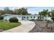 Charming blue single-story home with a well-manicured lawn, beautiful landscaping, and a circular driveway at 625 Worthington Dr, Winter Park, FL 32789