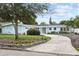 Inviting light blue home features a curved driveway, well-kept landscaping, and mid-century modern architectural details at 625 Worthington Dr, Winter Park, FL 32789