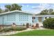 A cozy light blue home showcasing a welcoming front porch with white chairs and mid-century modern decorative elements at 625 Worthington Dr, Winter Park, FL 32789