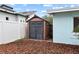 Backyard view of a well-maintained storage shed with black double doors and horizontal siding at 625 Worthington Dr, Winter Park, FL 32789