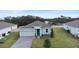 Aerial view of a single-Gathering home with solar panels, a brick paved driveway, and a manicured lawn at 663 Fairview Ave, Haines City, FL 33844