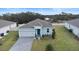 Drone shot of a single-Gathering home highlighting the manicured lawn, two-car garage, and the home's layout at 663 Fairview Ave, Haines City, FL 33844