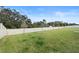 A view of the grassy backyard featuring a tall white fence at 663 Fairview Ave, Haines City, FL 33844
