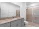 Bright bathroom featuring a granite vanity top, gray cabinets, and a glass-enclosed shower at 663 Fairview Ave, Haines City, FL 33844